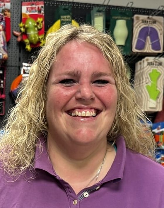 Eigenaar Birgit Broekhuizen in de winkel, voor de wand met speelgoed